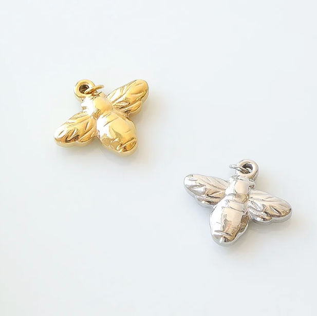 Gold and silver bee-shaped charms on a white background